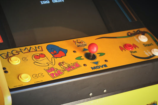Yellow Arcade Machine with Pac Man stickers on it